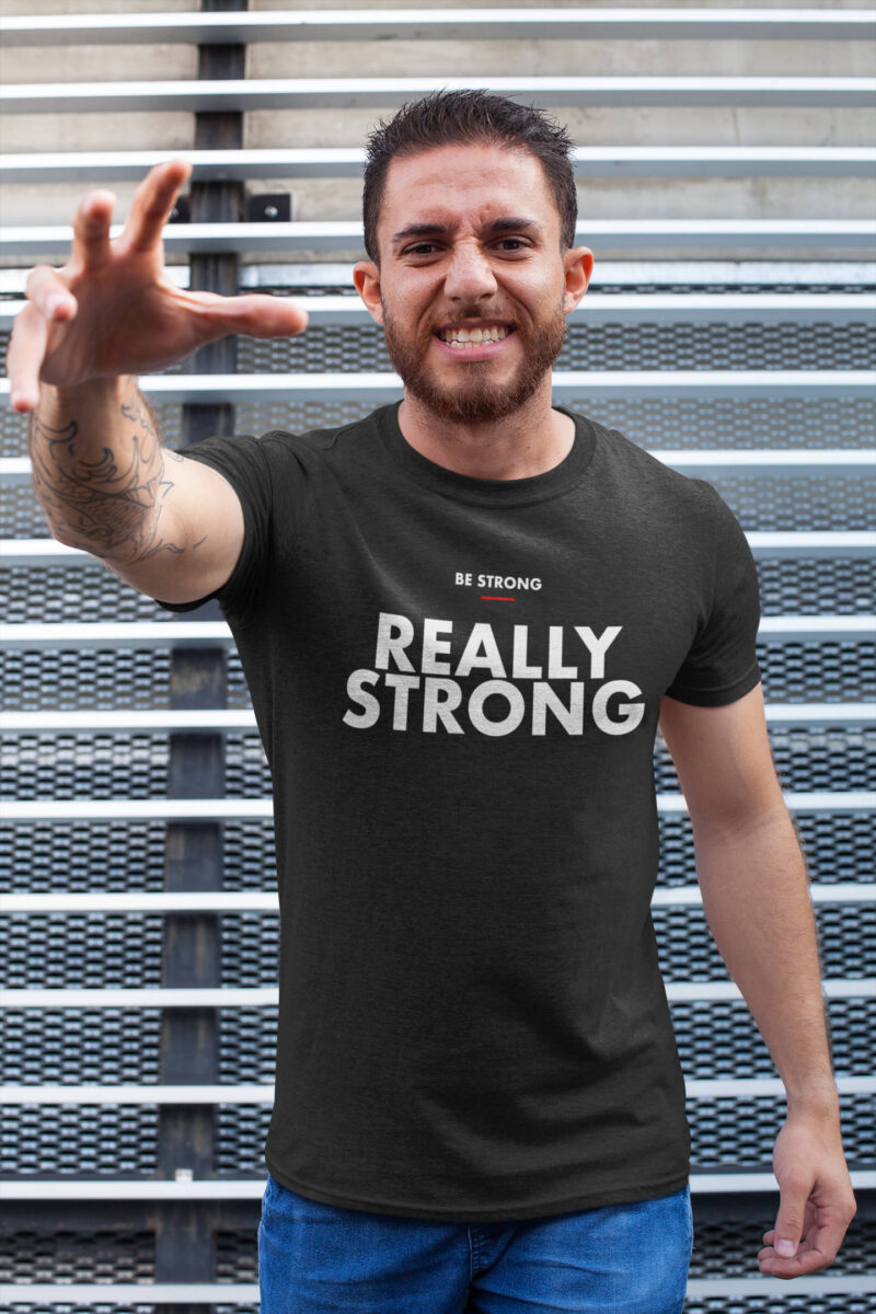 man doing a menacing pose while wearing a black be strong t-shirt